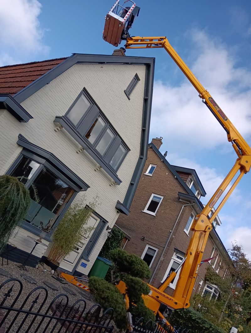 Werkzaamheden aan dak en gevel van een woning met een hoogwerker